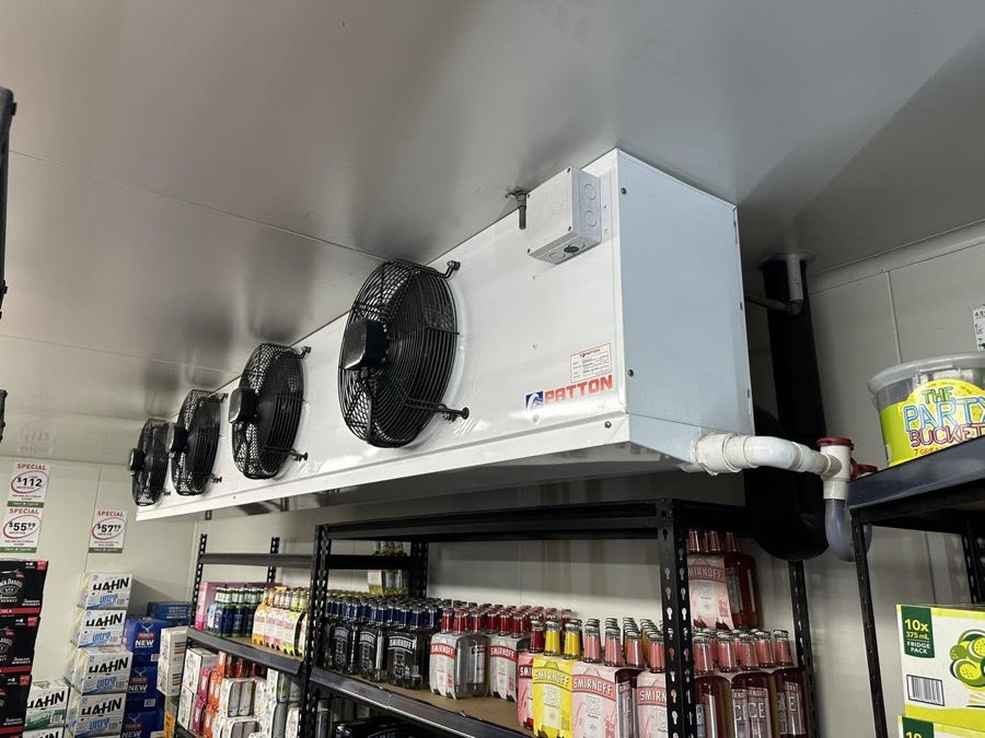 A refrigeration evaporator mounted above stocked shelving in a cool room