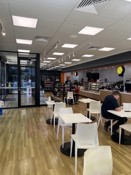 A finished cafe fit-out with seating, lighting and a serving counter